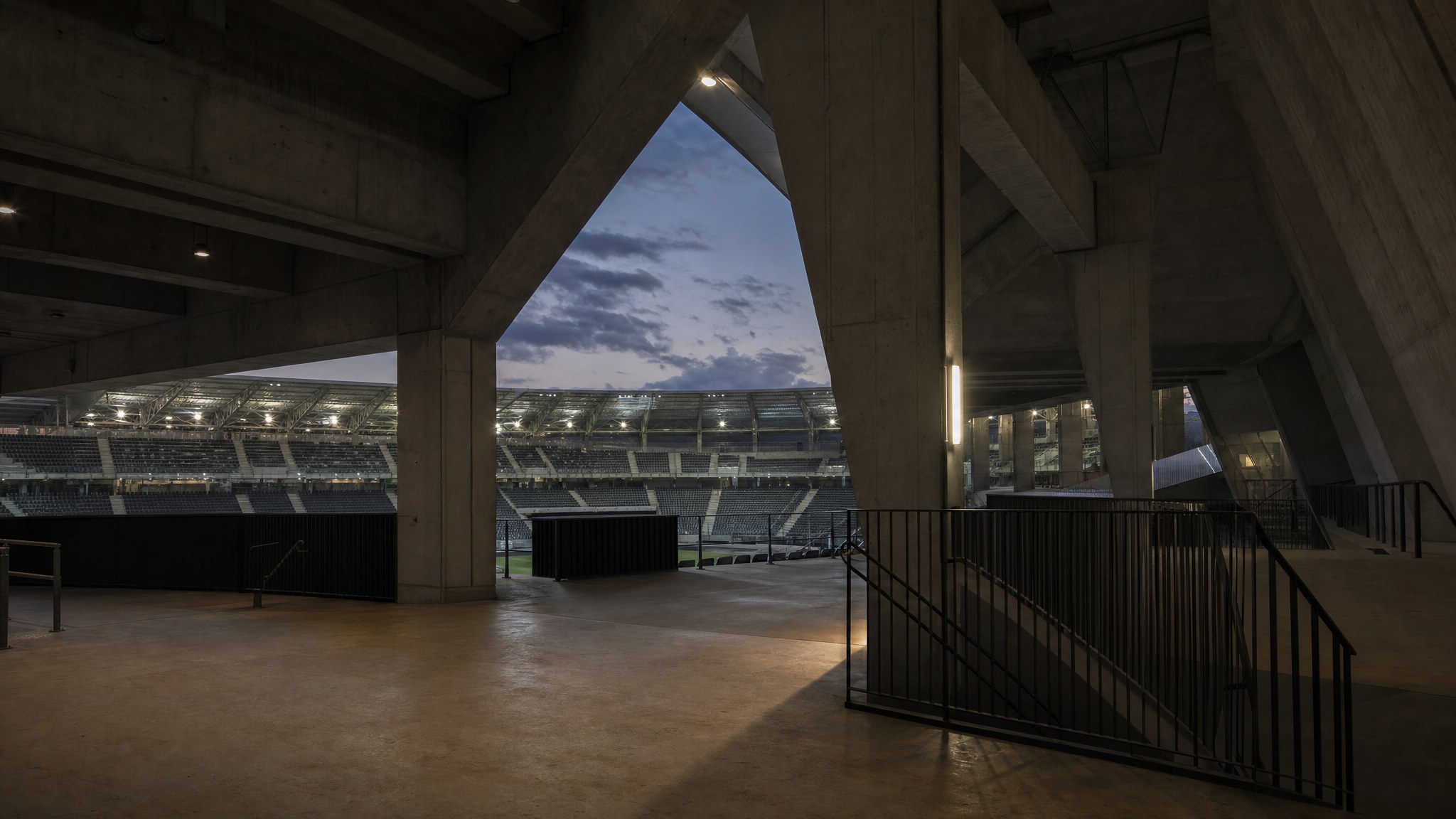 An empty football stadium concourse with seating visible at dusk