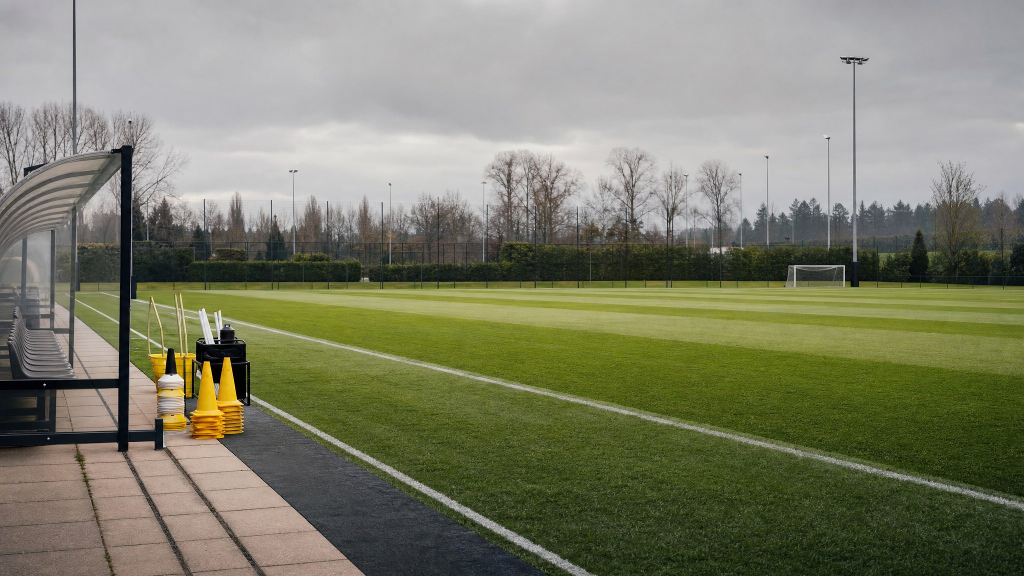 An empty professional football training pitch with equipment beside the technical area