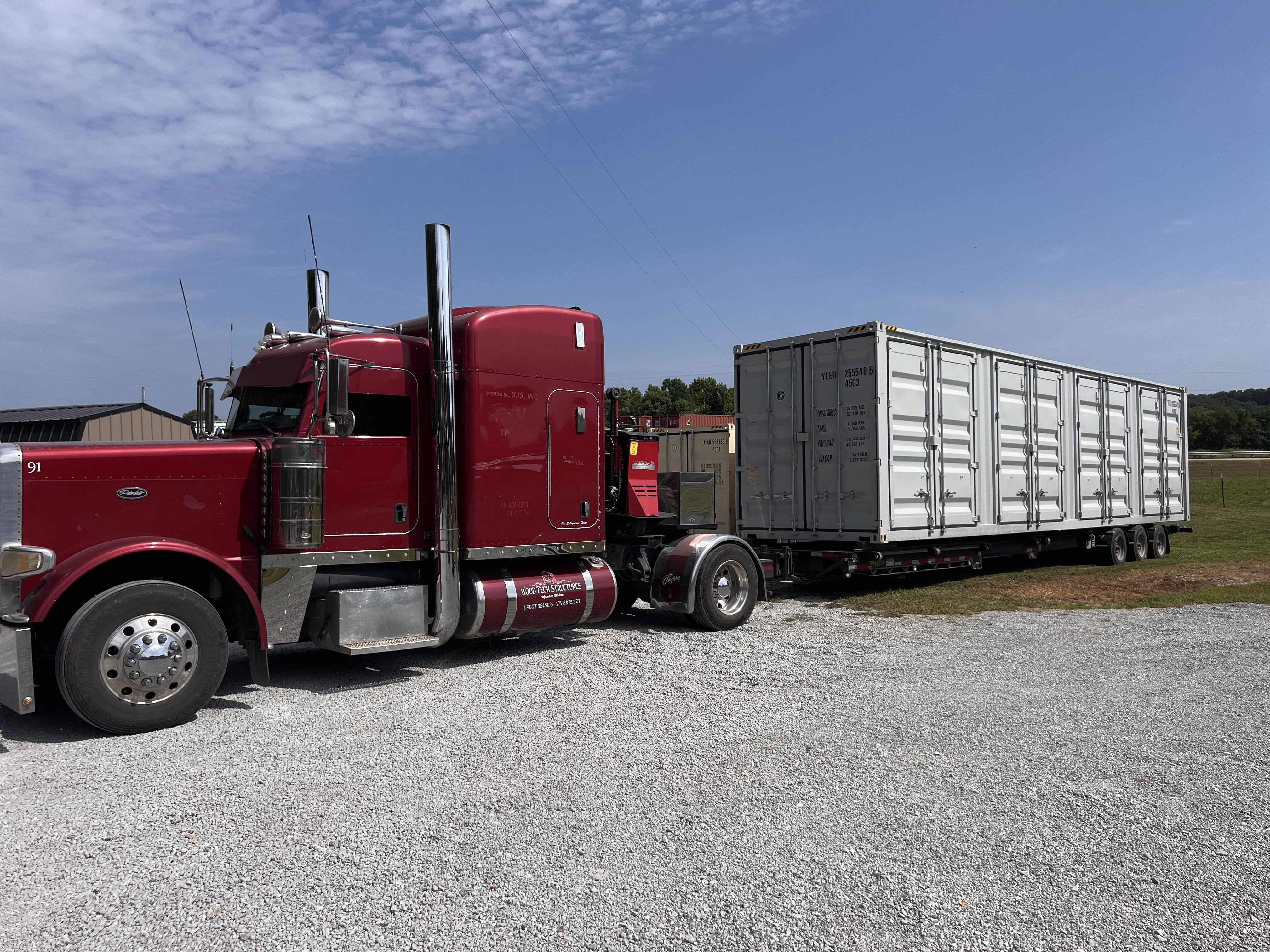 Wood Tech delivery truck hauling a shipping container