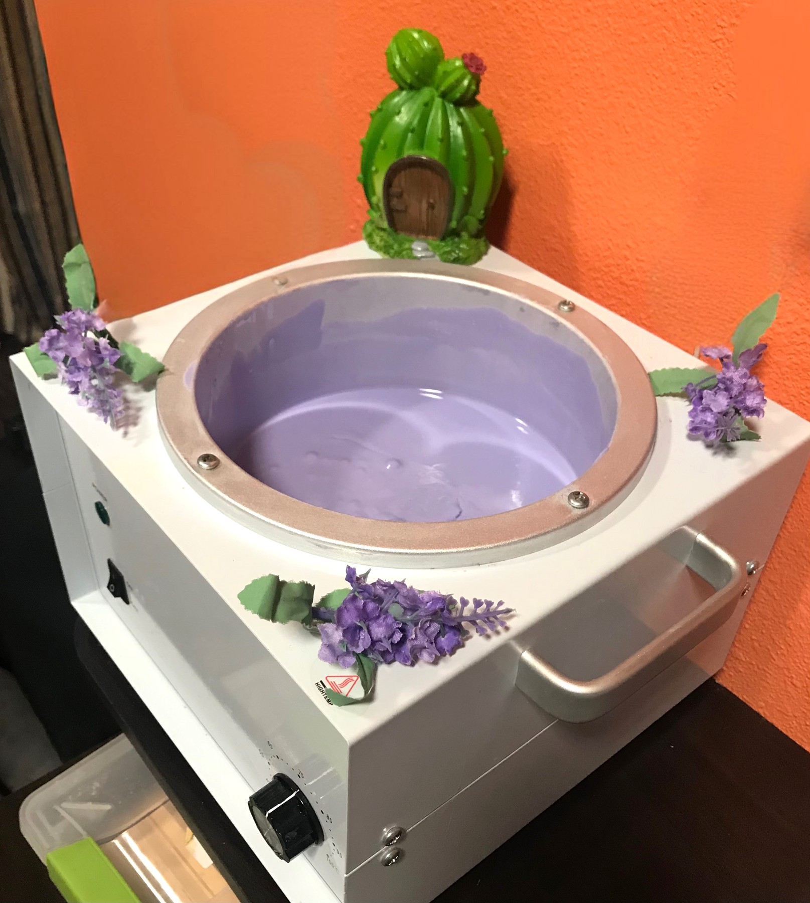 Arize’s wax warmer with purple wax and floral decorations