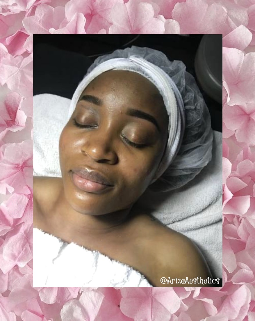 Client resting during facial care at Arize, framed with pink petals
