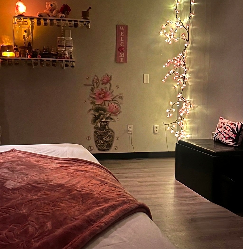 Arize’s treatment room with a quilted treatment bed and glowing blossom lights