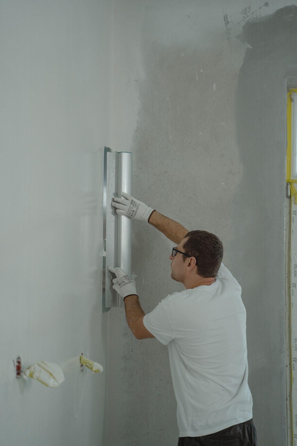 Contractor finishing an interior wall during reconstruction