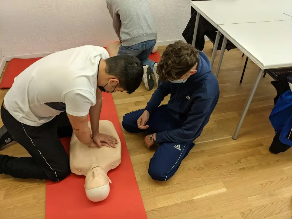 Students practicing CPR skills with a training manikin