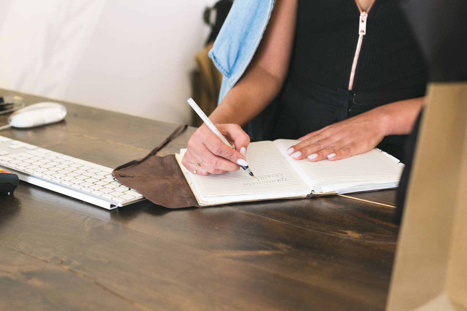 Small business owner making notes beside a computer