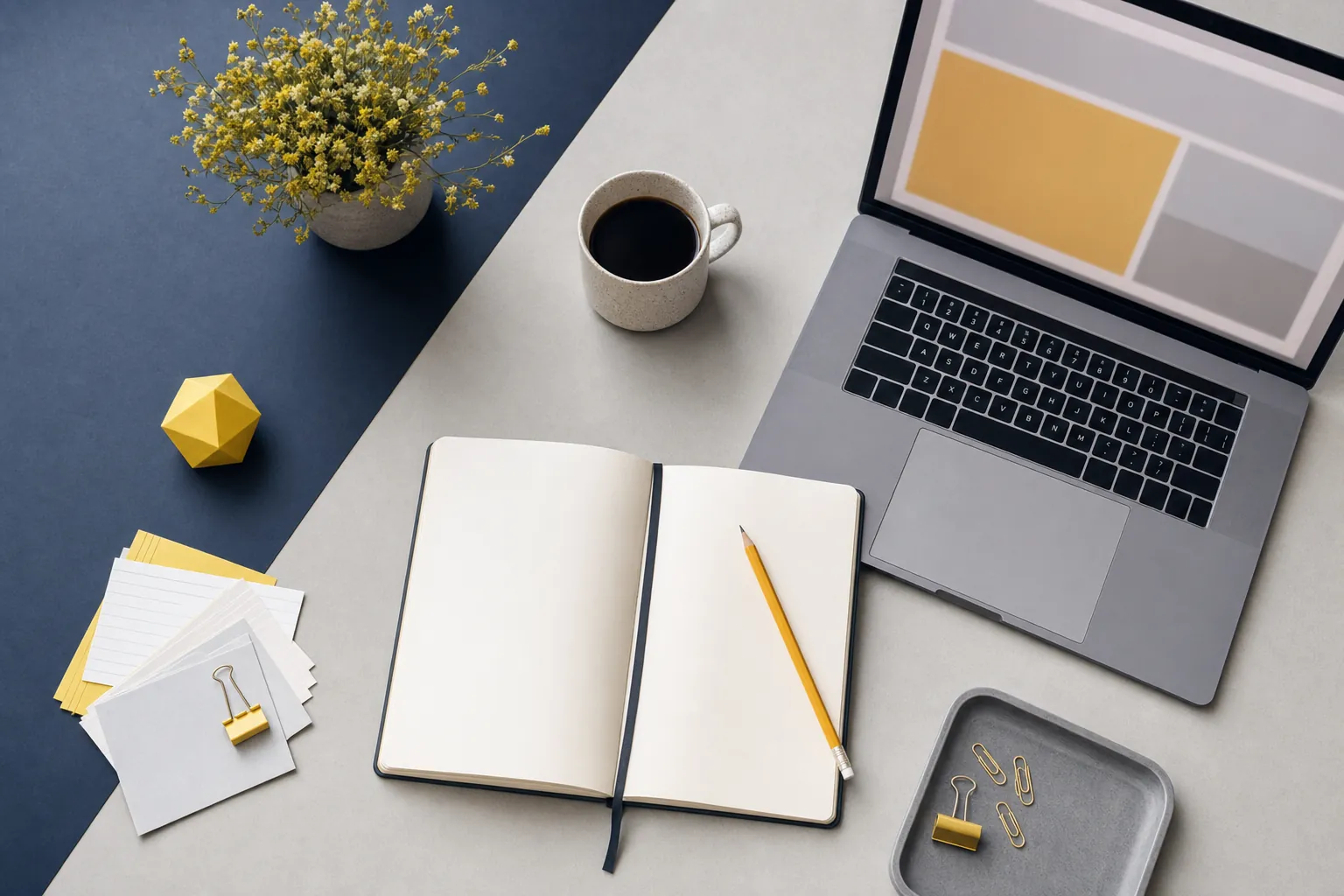 Notebook, pencil, paper cards, and laptop arranged for website copy planning