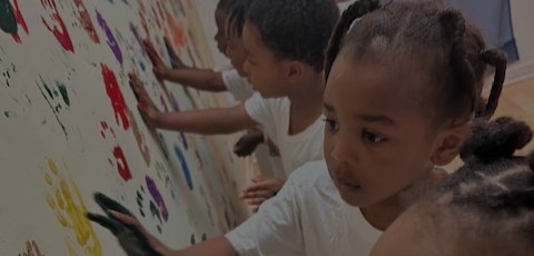 Children creating a colorful handprint mural