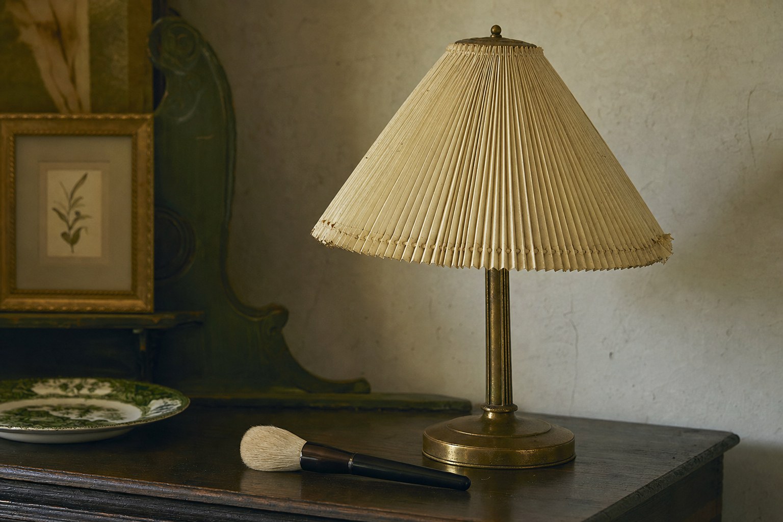 Pleated paper lampshade with a soft brush on a dark wood table