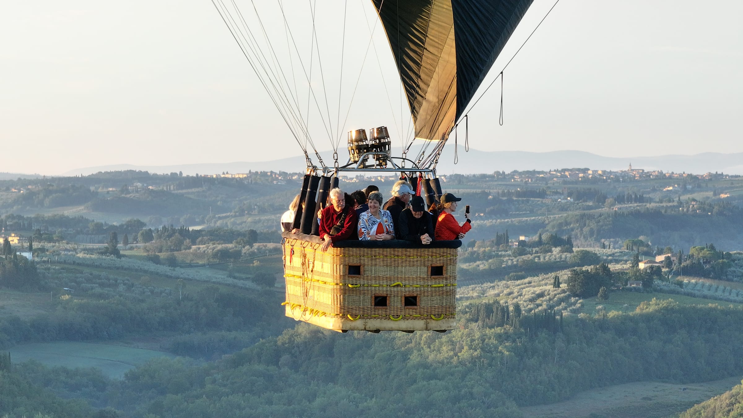 Travelers floating above the Tuscan countryside in a hot-air balloon