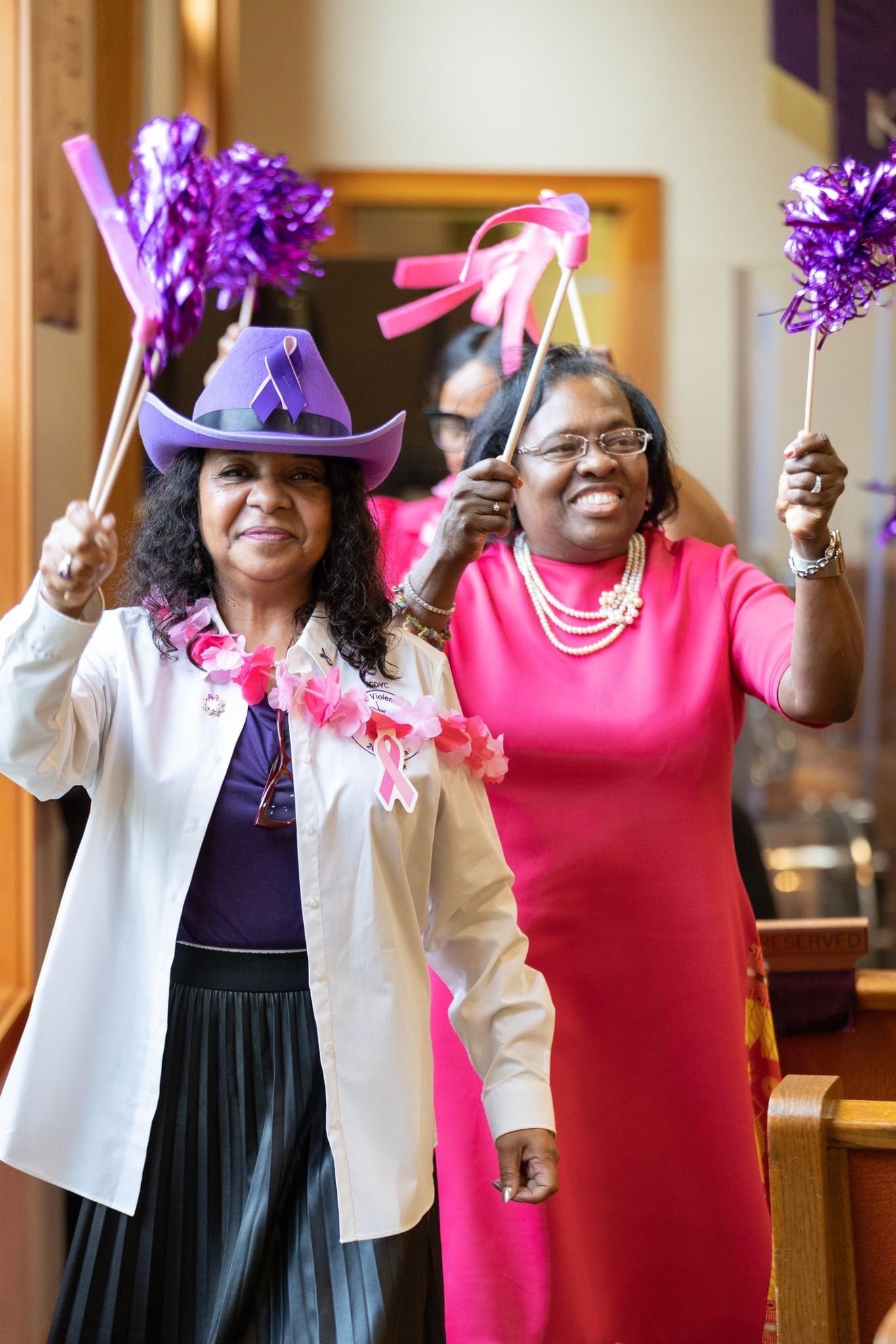 Guests celebrating with pink and purple pom-poms