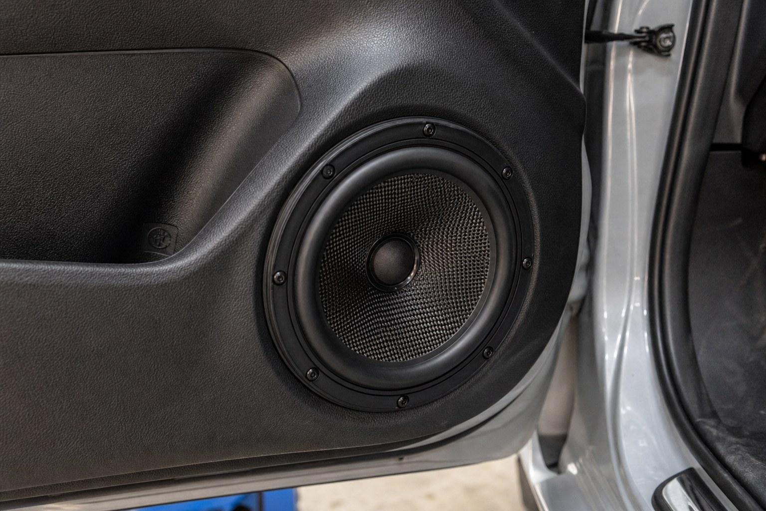 Aftermarket car door speaker fitted neatly into a vehicle door panel