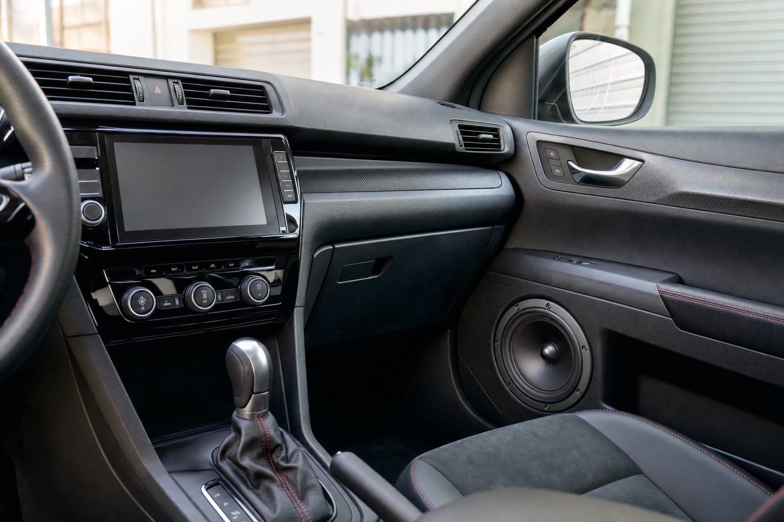 Modern car interior with a touchscreen stereo and door speaker