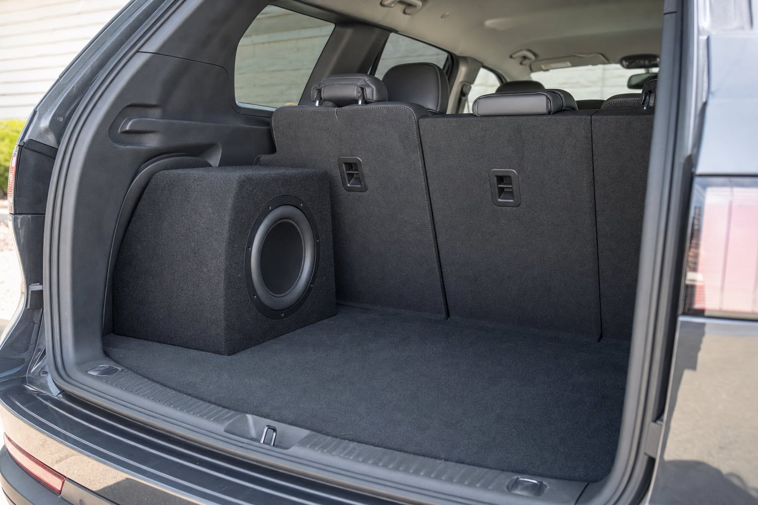 Compact subwoofer enclosure installed in a clean SUV cargo area