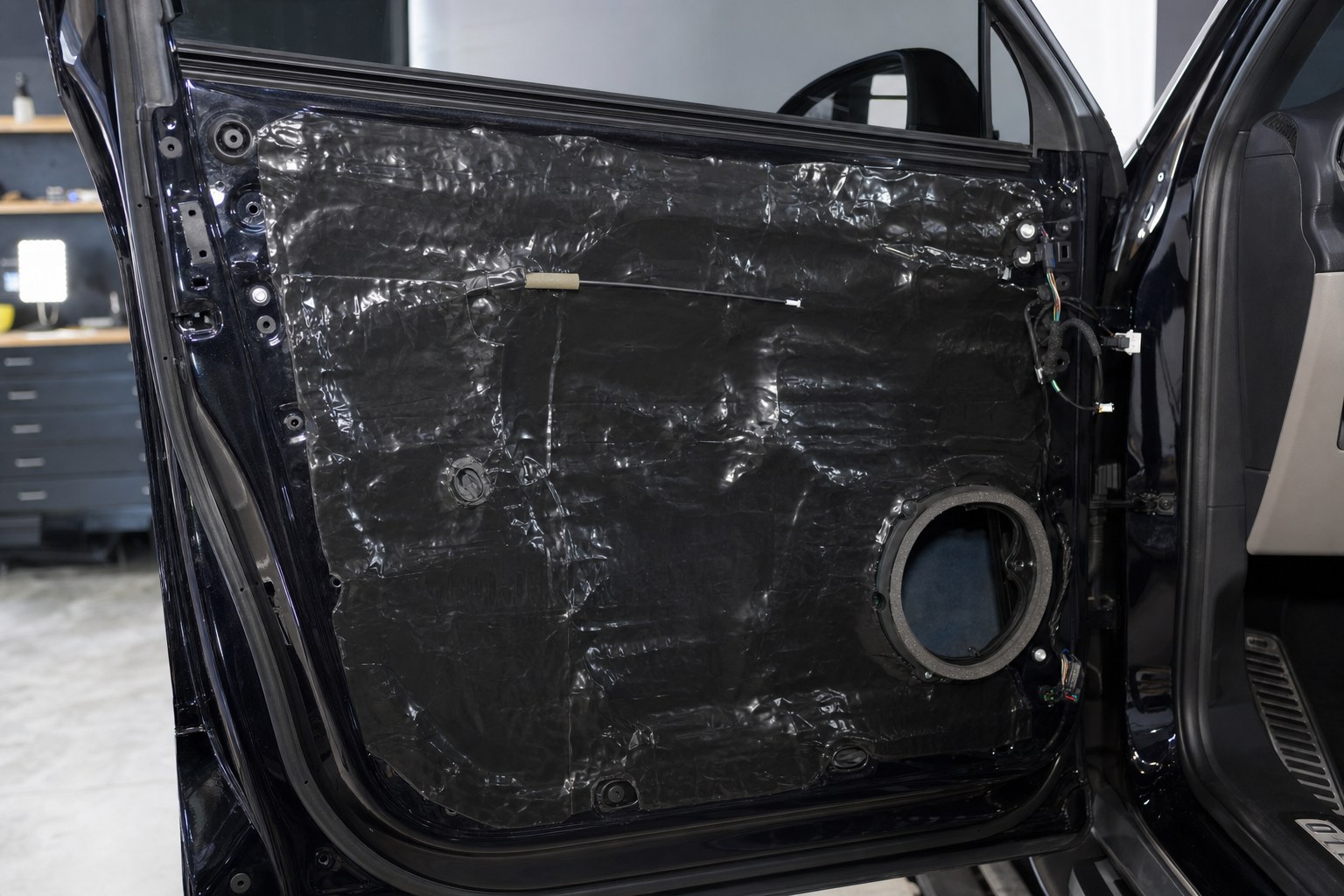 Vehicle door prepared with sound-deadening material during a car audio installation