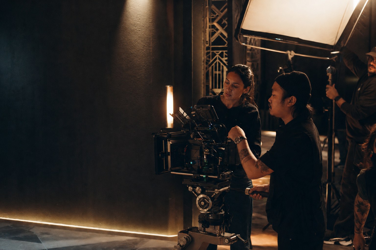 Film crew shaping a cinematic brand film on a warm, dark production set