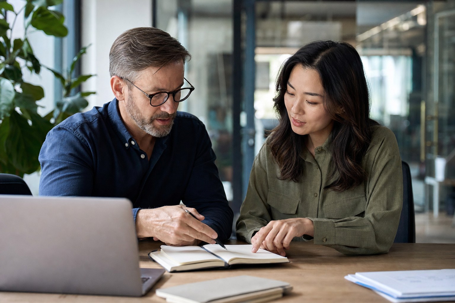 A manager and employee reviewing priorities together in a notebook