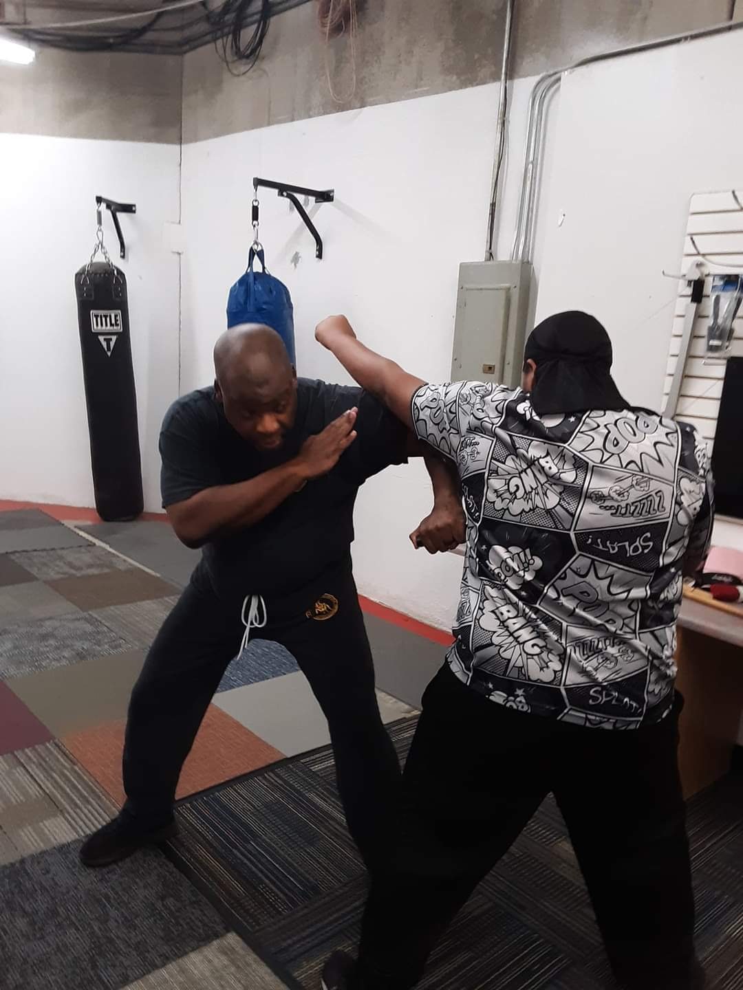 Two participants demonstrating a defensive tactics technique in a training room