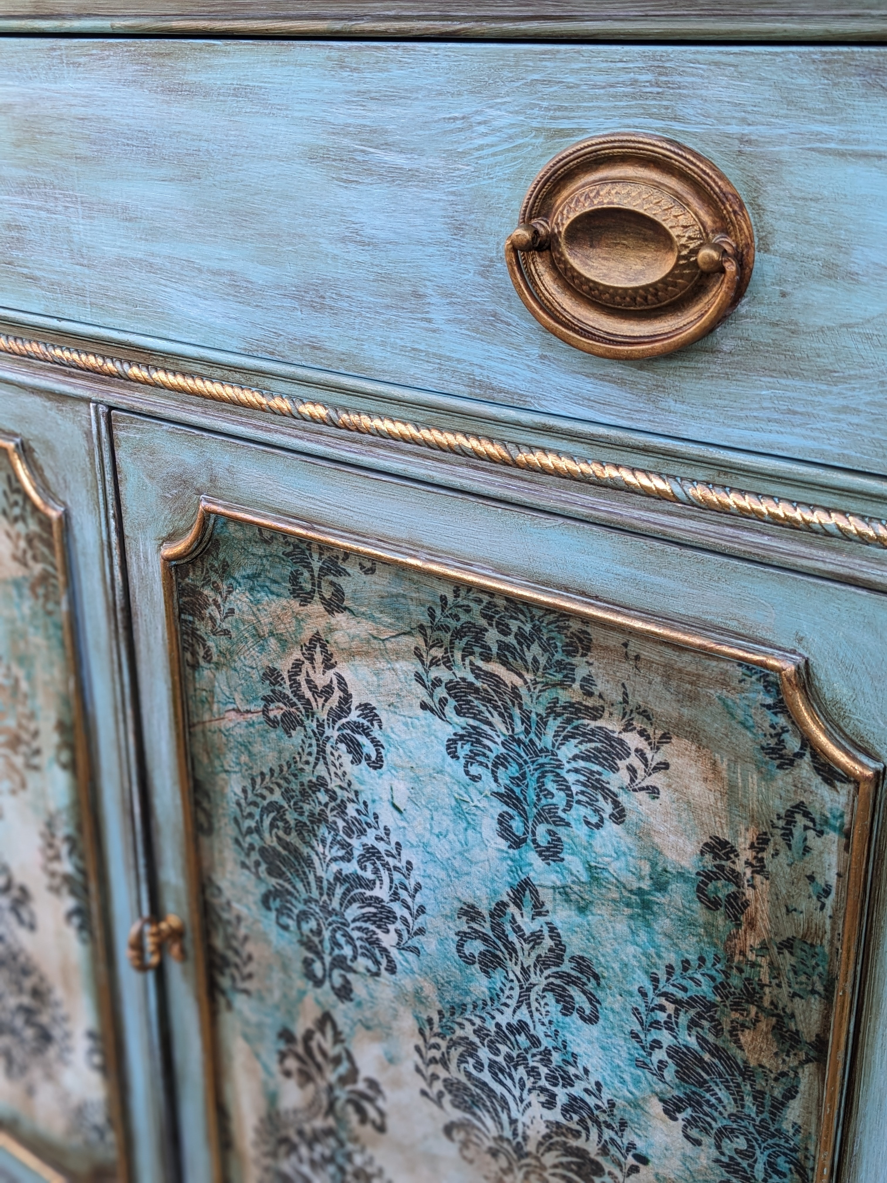 Turquoise cabinet detail with damask decoupage, copper trim, and original hardware