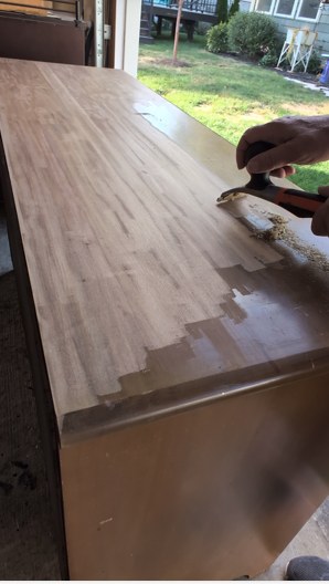 Sondra using a carbide scraper to remove an old finish from a vintage piece