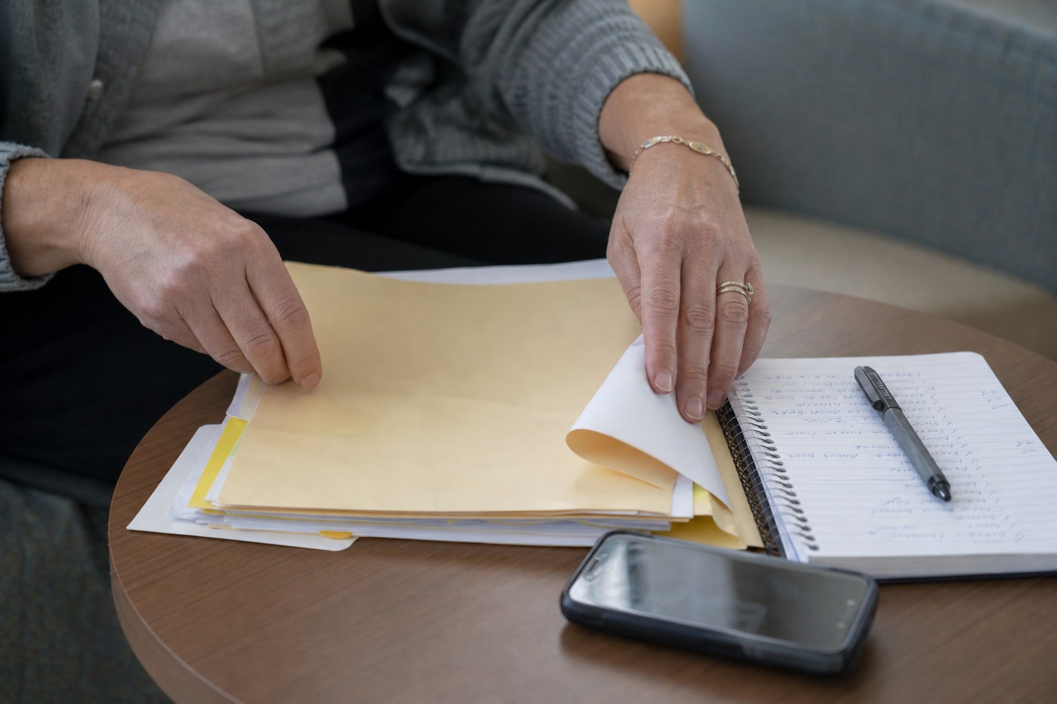 Hands reviewing a care-planning folder and notebook