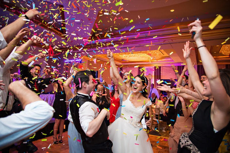 Guests celebrating beneath confetti at a wedding reception