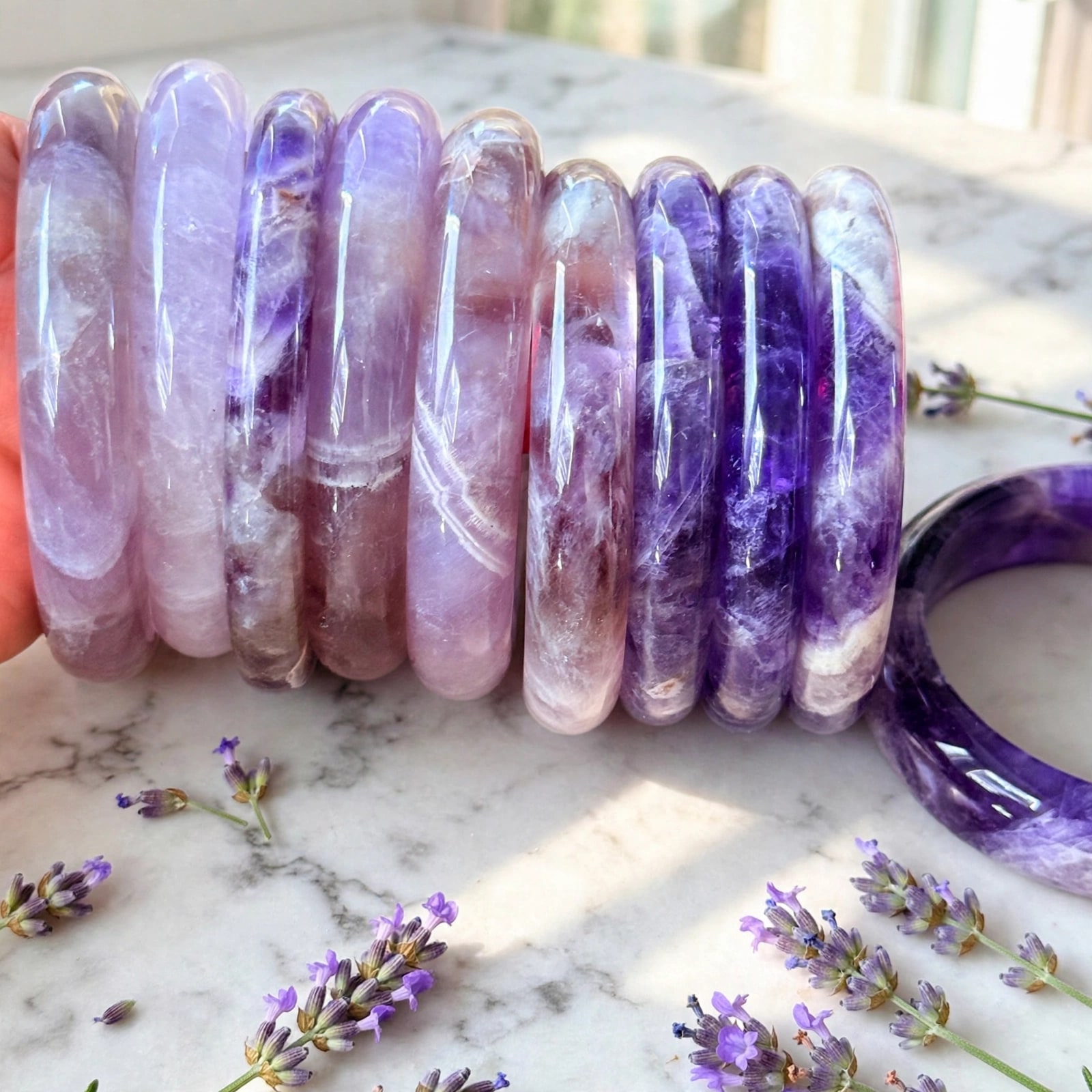 Natural amethyst crystal bangle on a marble surface