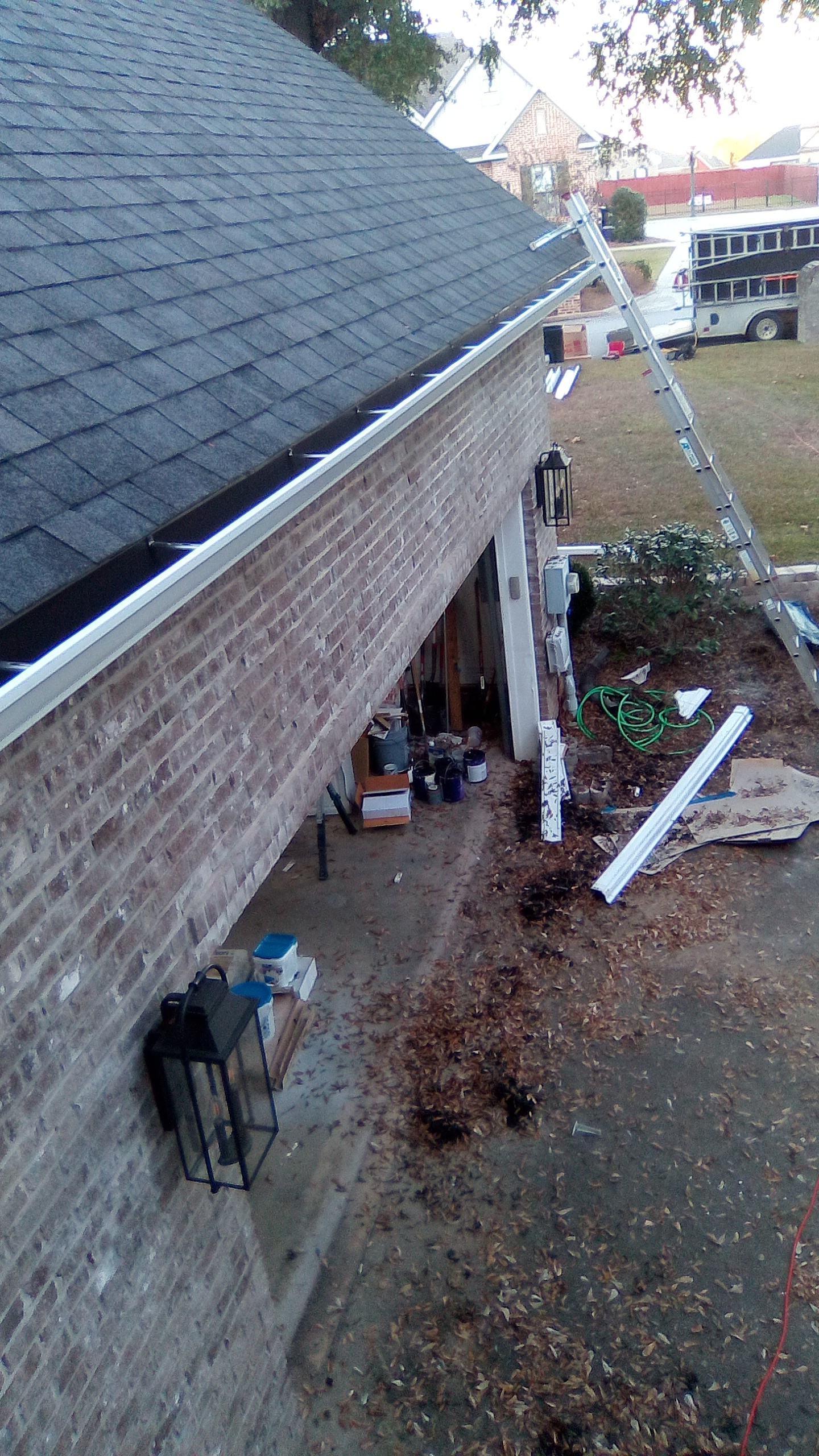 Gutter installation along a brick home roofline