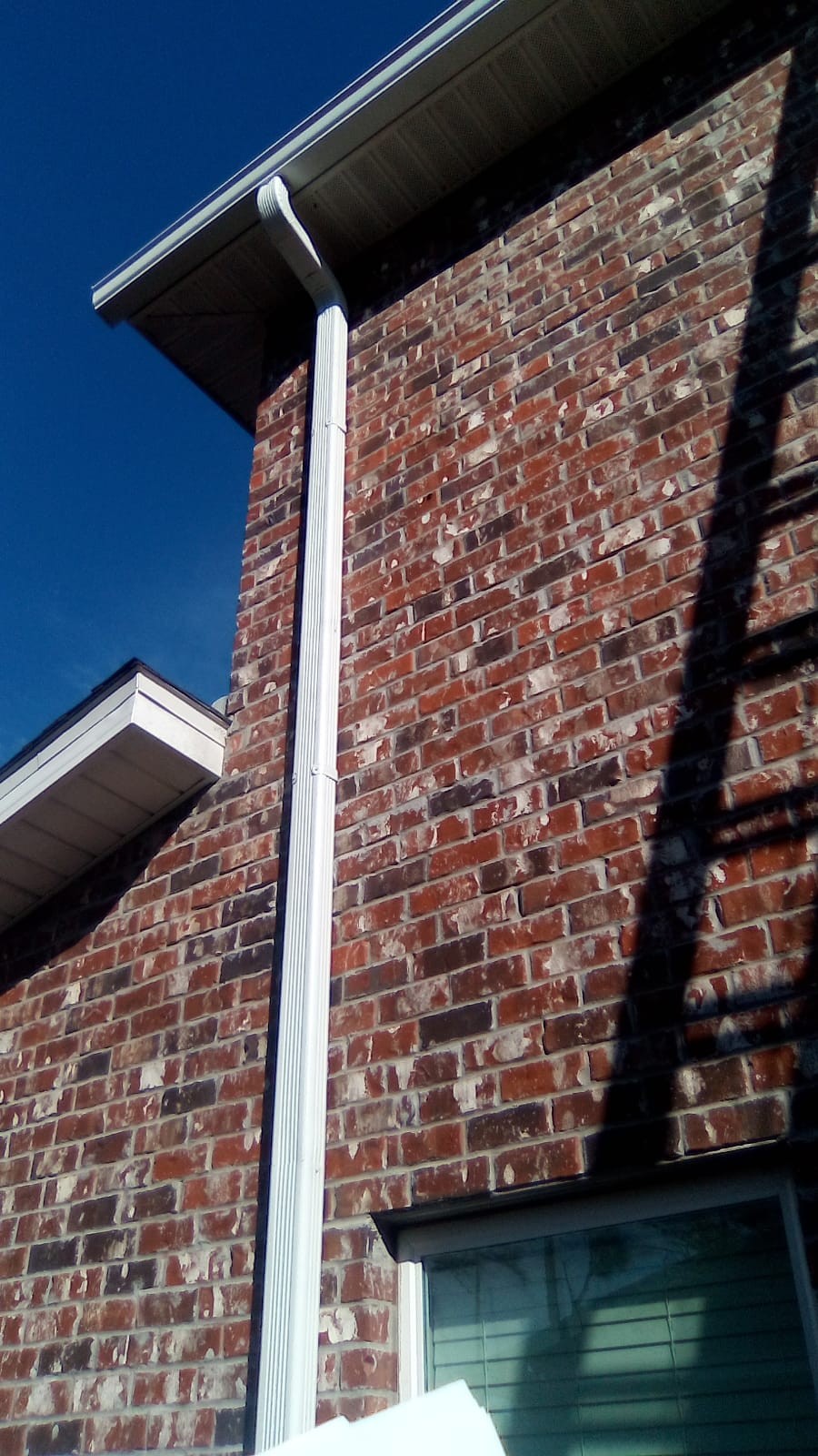 Gutter installation at a brick roofline