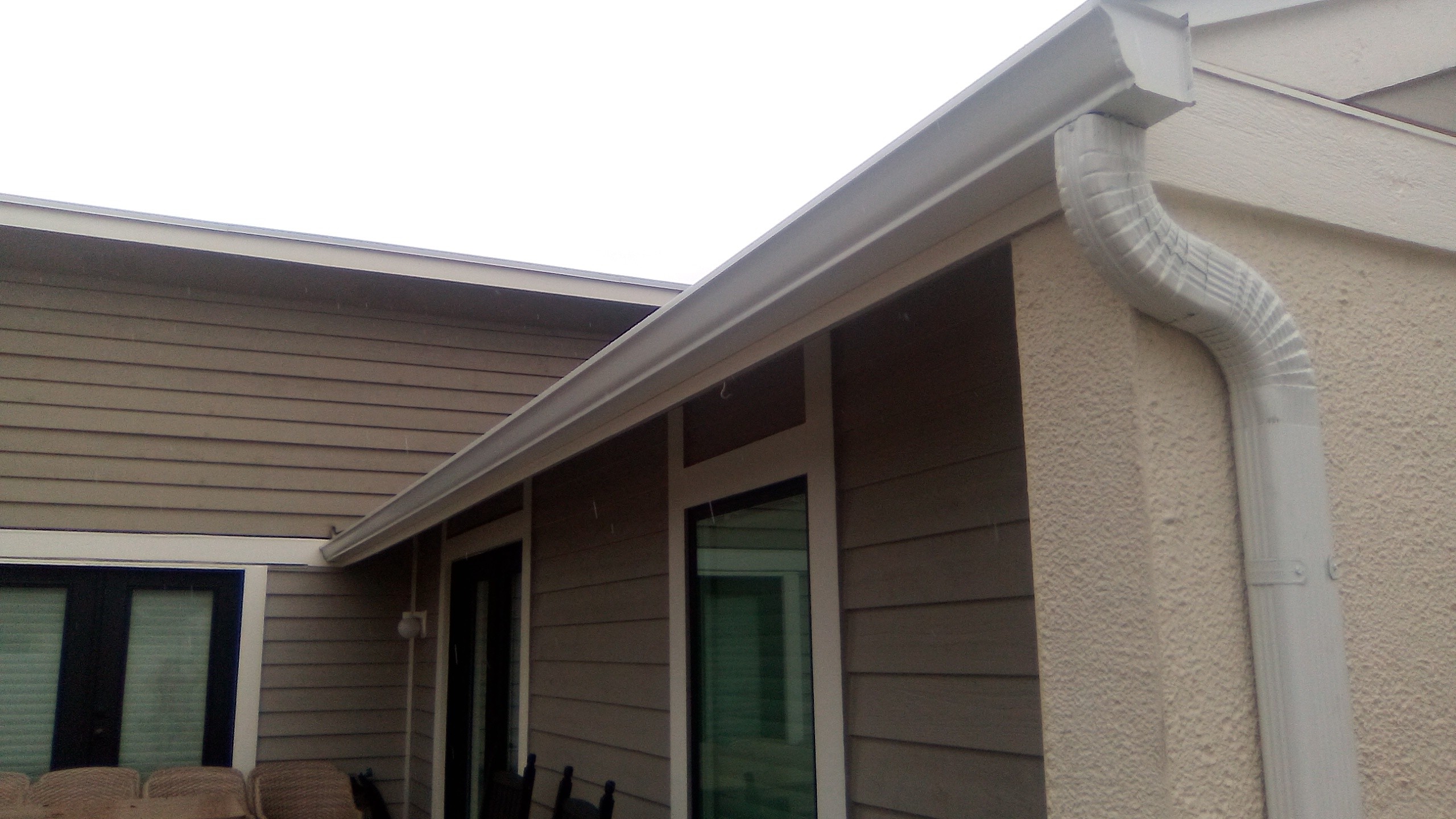 White gutter and downspout at a covered patio