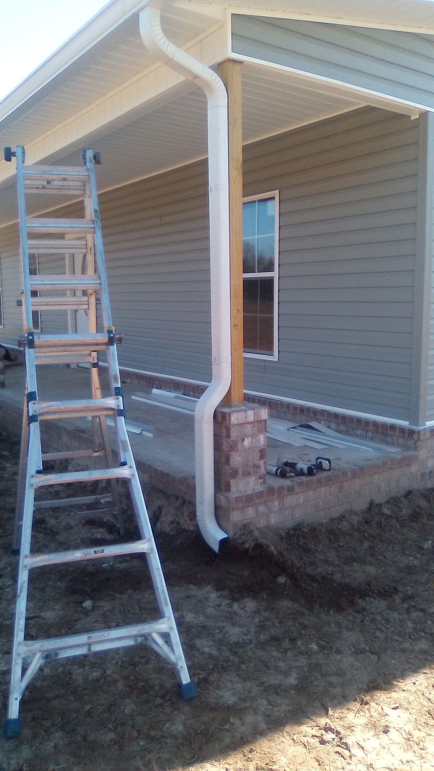 Finished white downspout on a home exterior