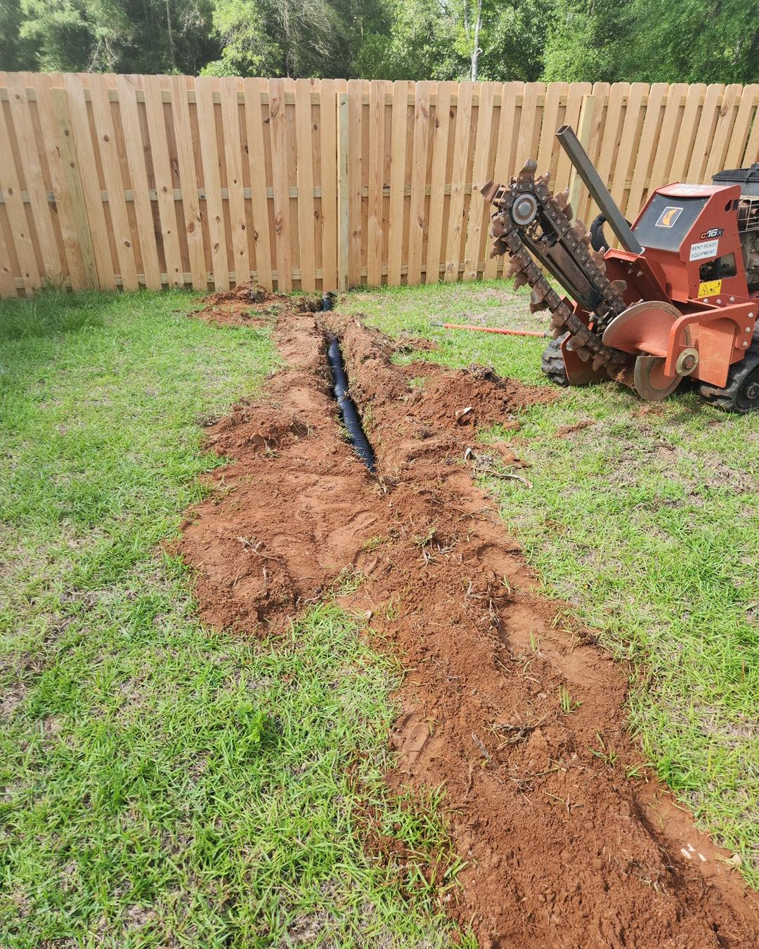 Drainage trenching and pipe installation in a residential yard