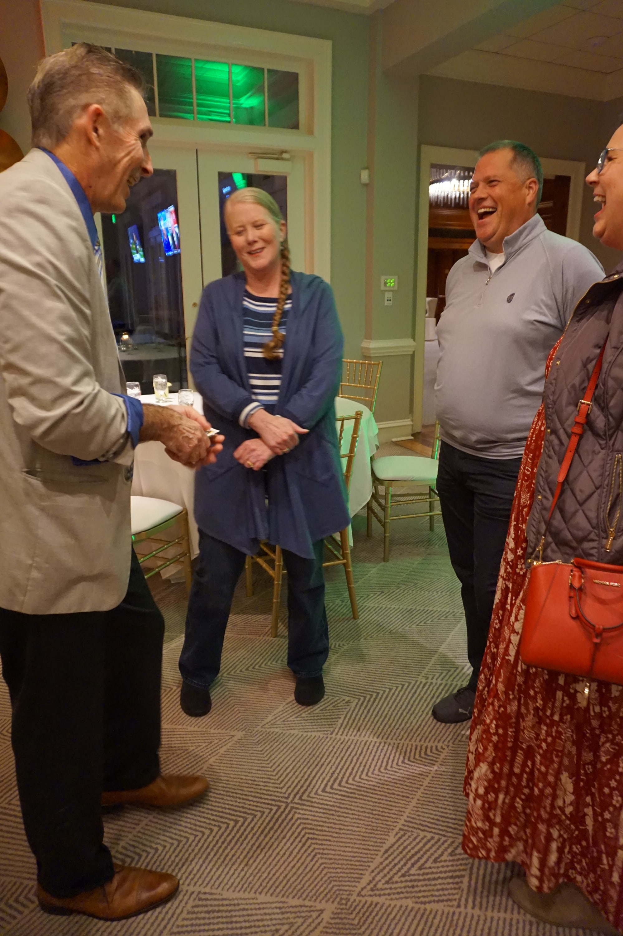 Guests smiling during a close-up magic moment at an event