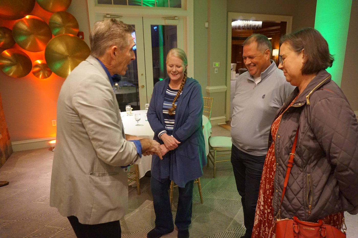 Zelnik speaking with a small group of guests at a company event
