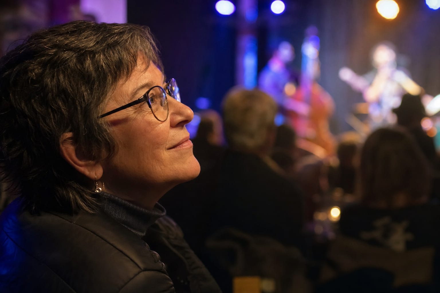 Woman listening closely to a live band in a small venue