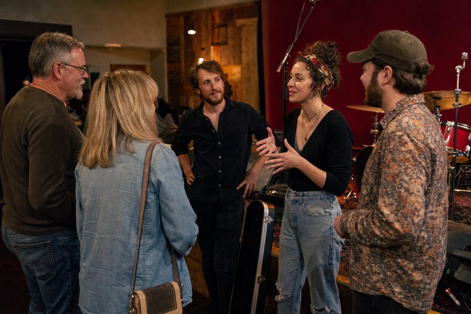 Audience members talking with local musicians after a small venue performance