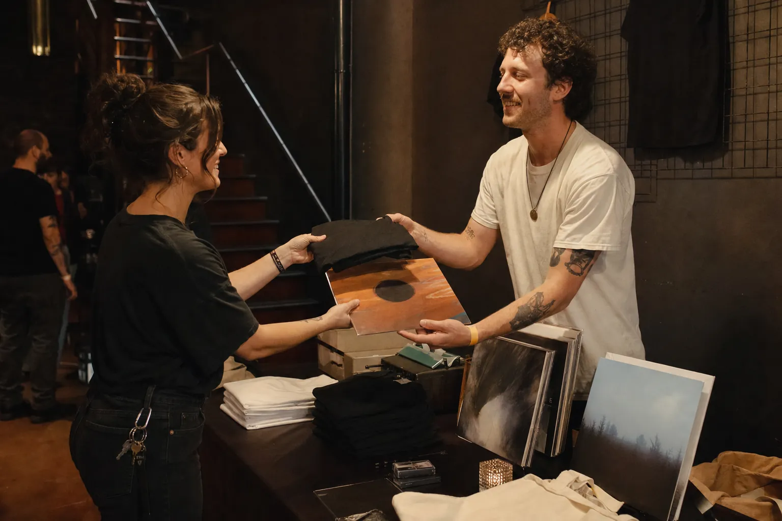 Listener buying a band shirt and vinyl record directly from a local musician