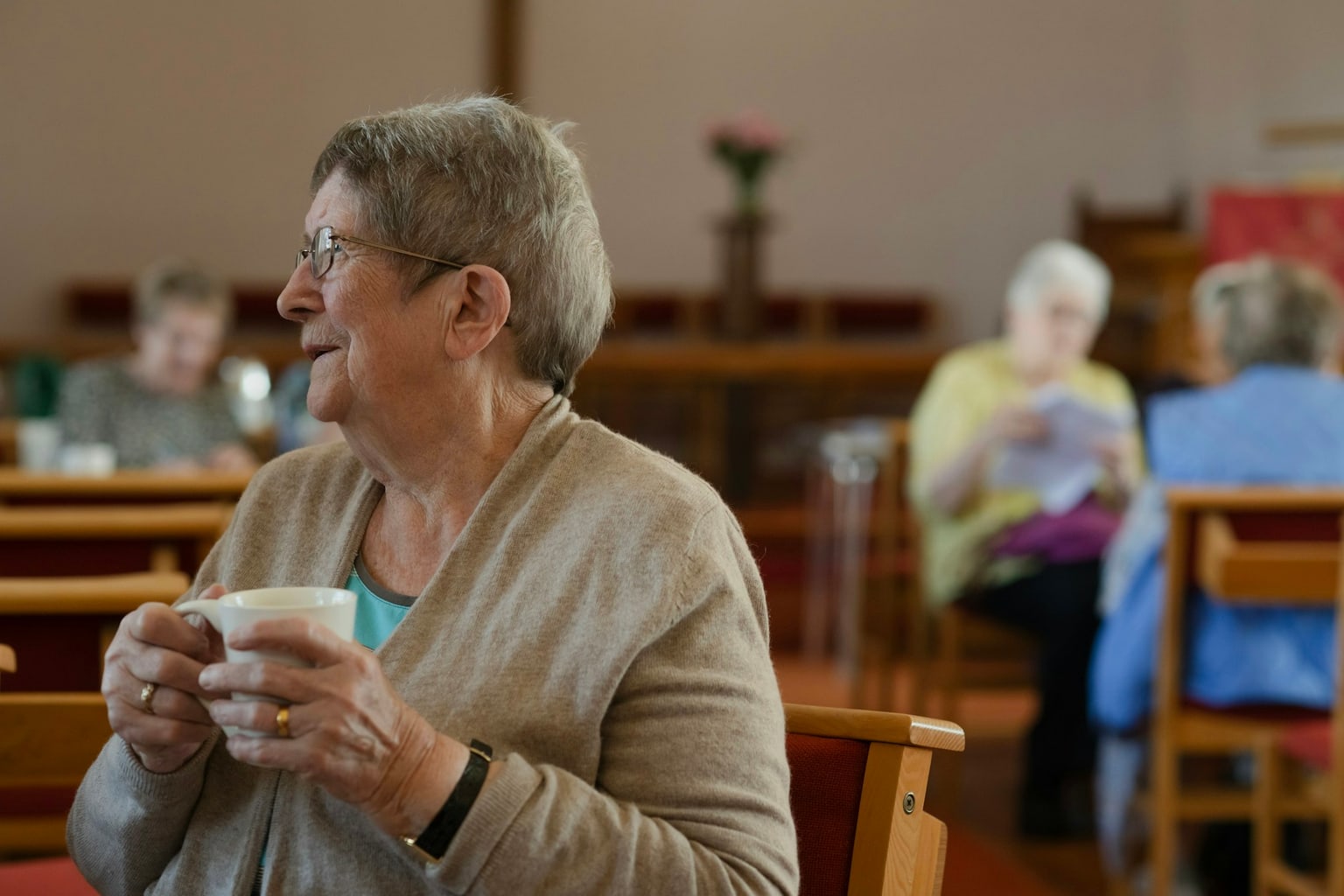 Woman enjoying coffee and conversation with familiar people in a cafe