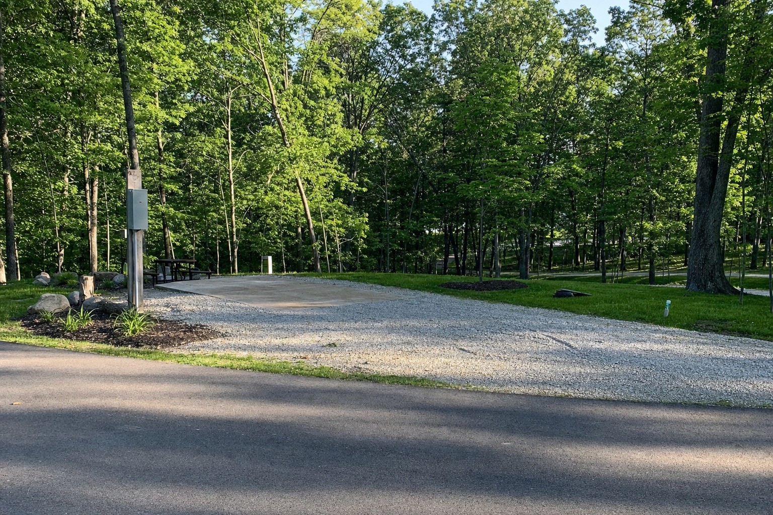 Prepared wooded RV site with a utility pedestal and a level pad