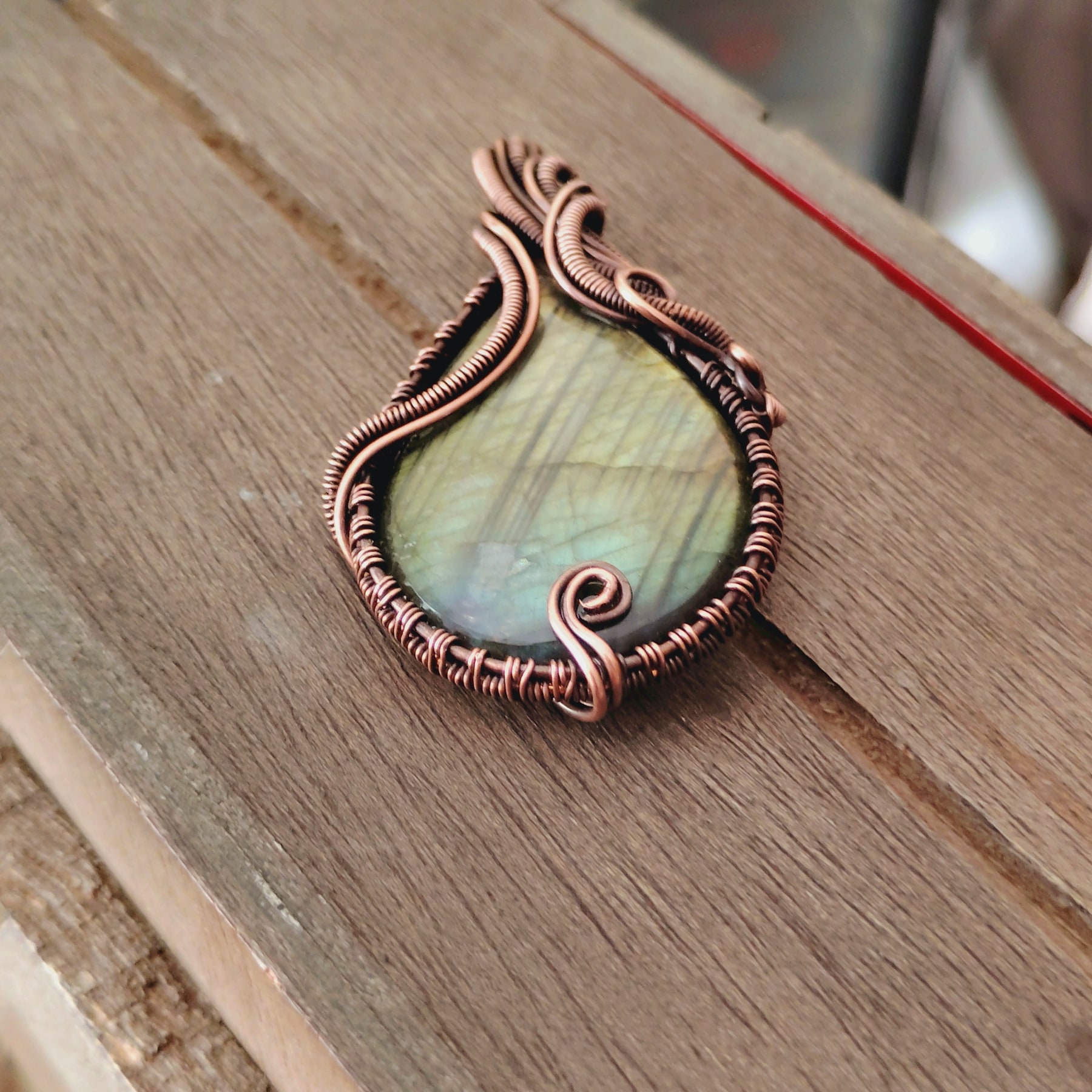 Close view of the oxidized copper wirework around a labradorite pendant