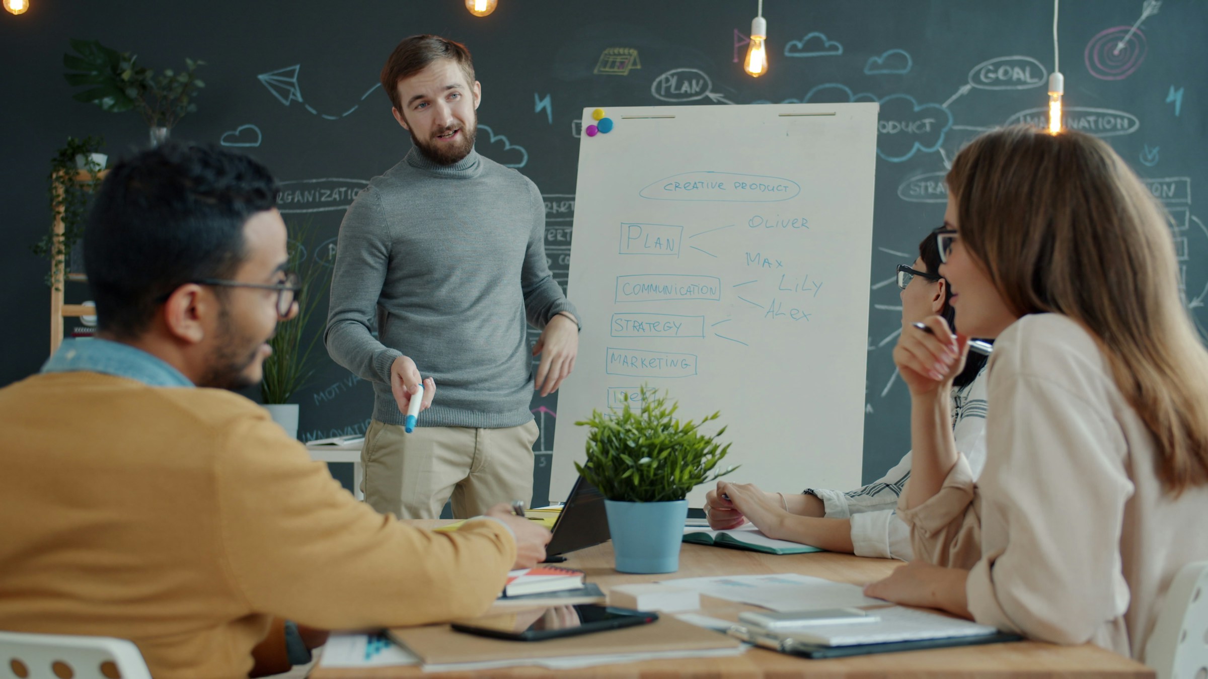 Colleagues collaborating around a whiteboard during a planning meeting