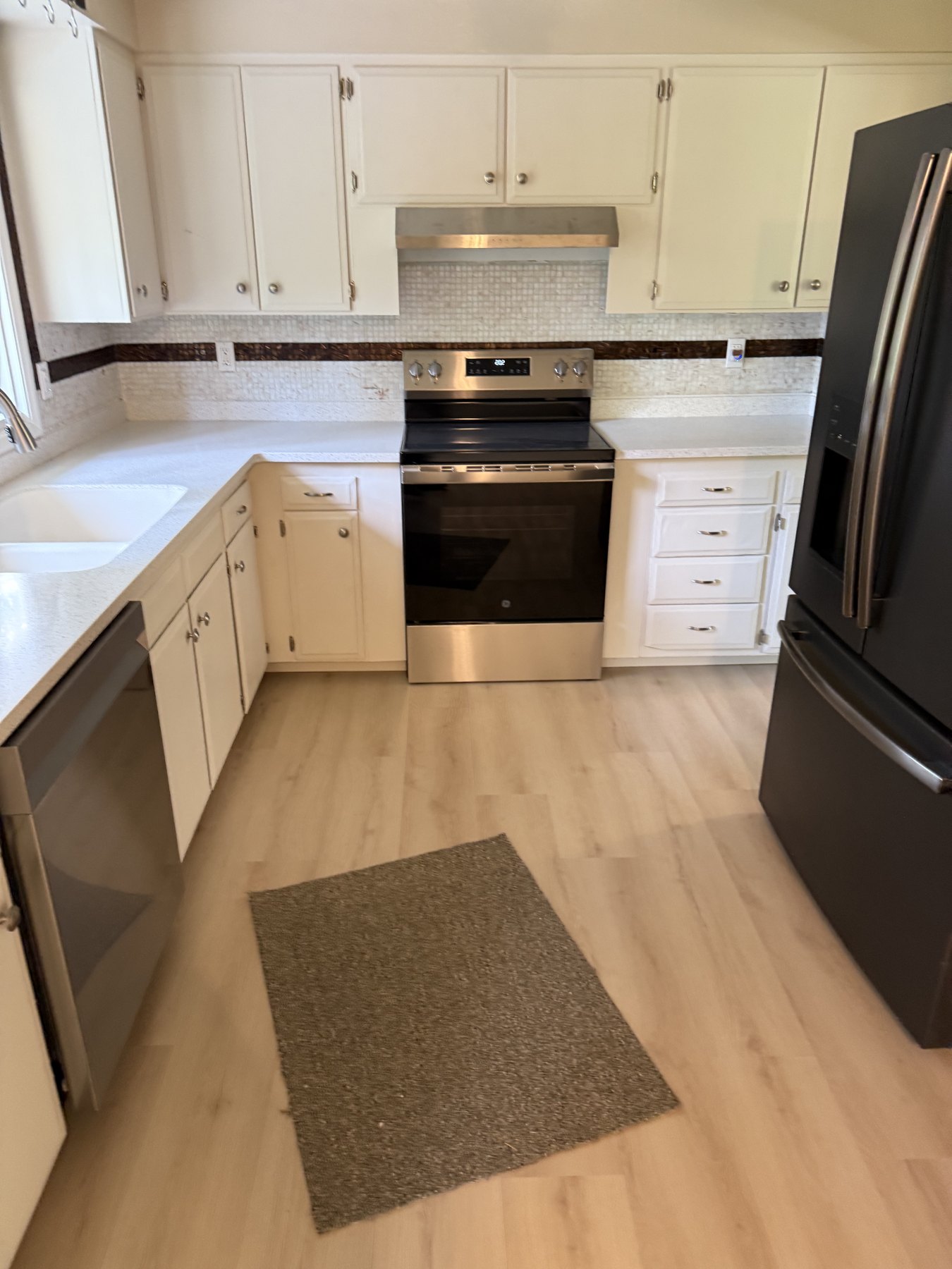 Bright kitchen with white cabinets and window above the sink