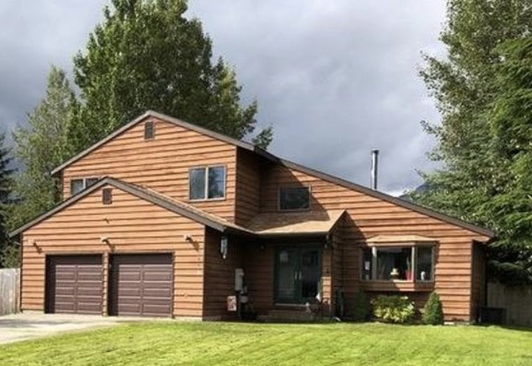 Cedar-sided home with covered entry and metal roofing
