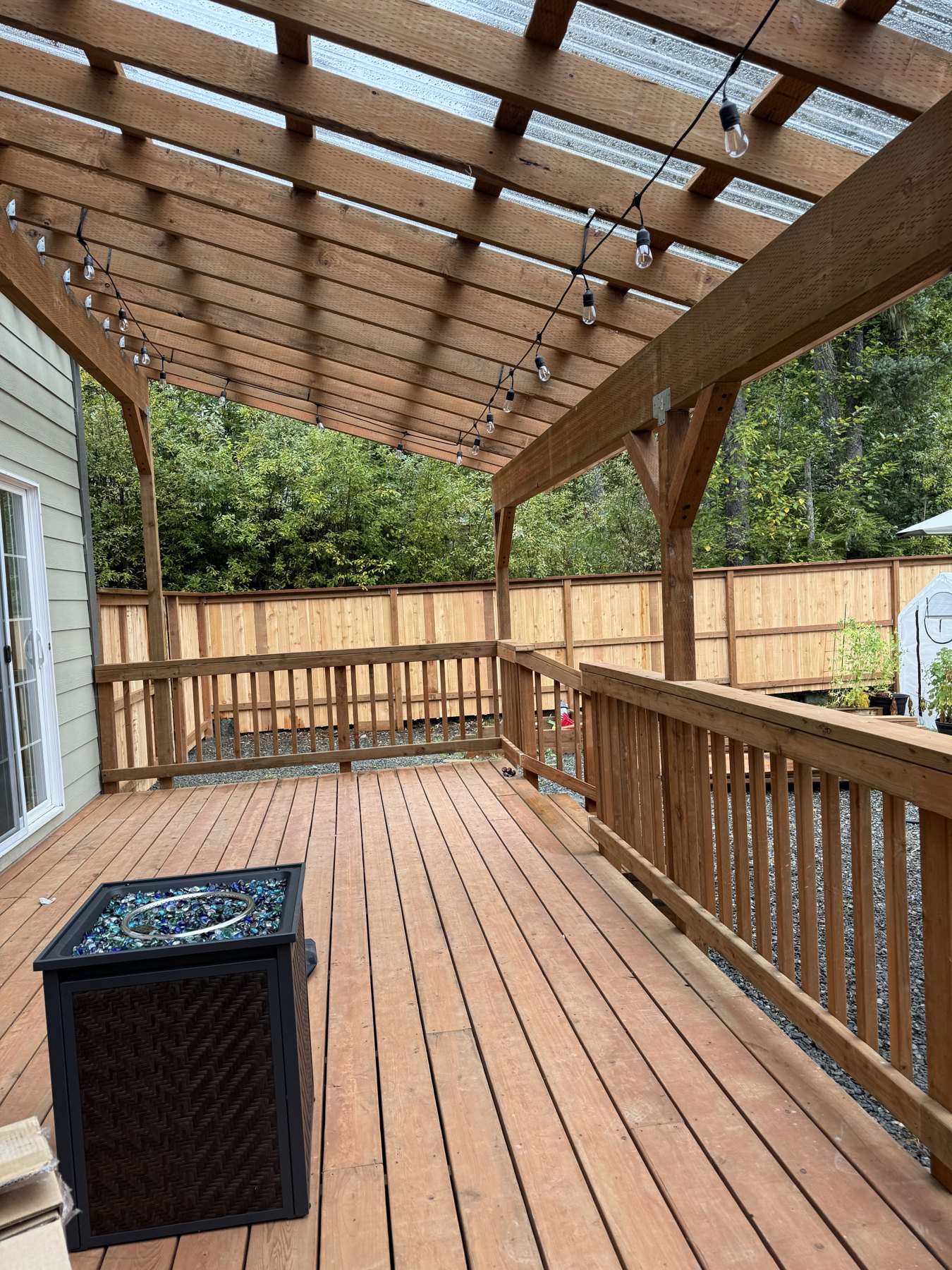 Covered deck with exposed overhead framing and wood railings