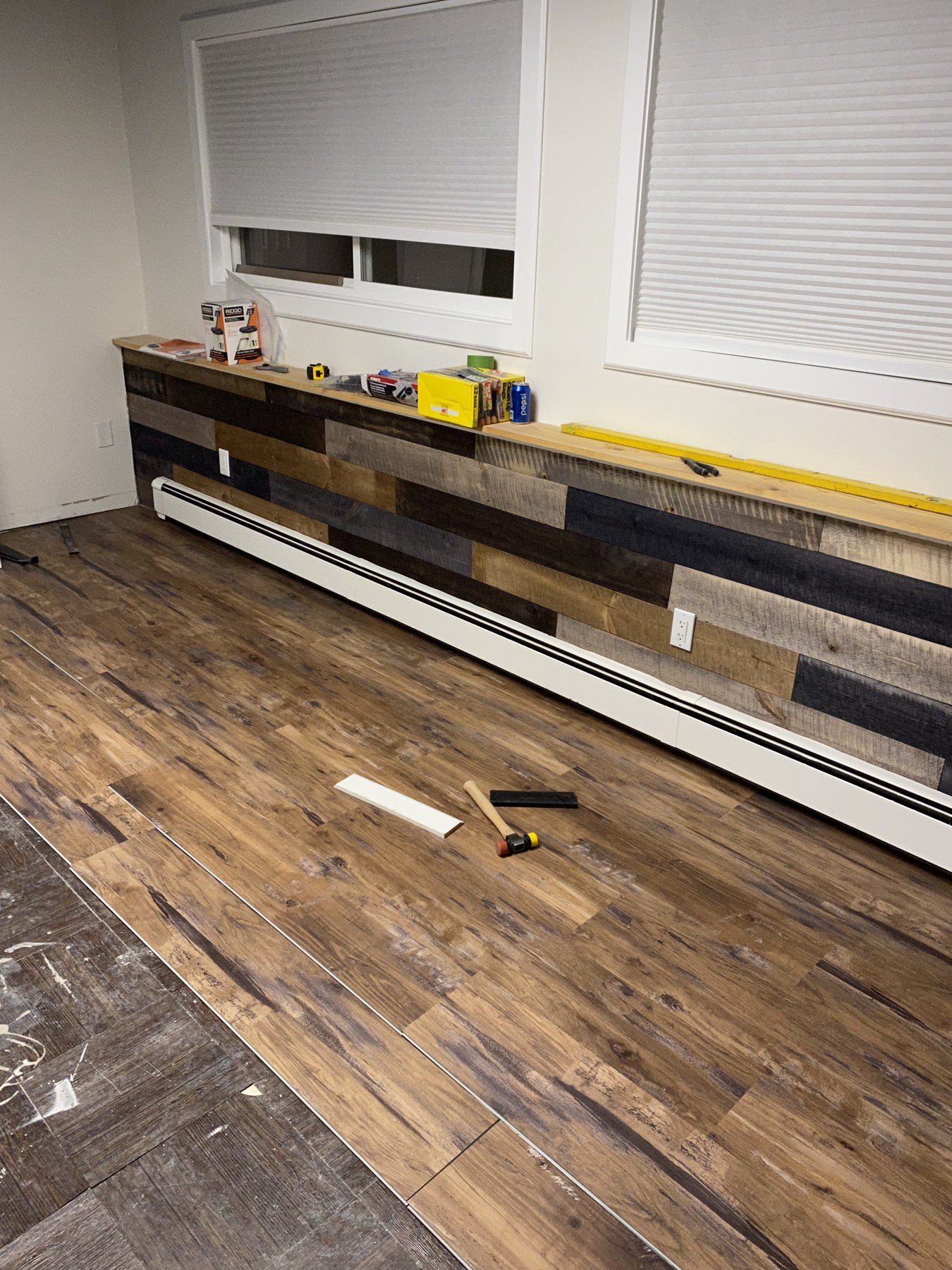 Interior flooring and wood wall accents beneath a window