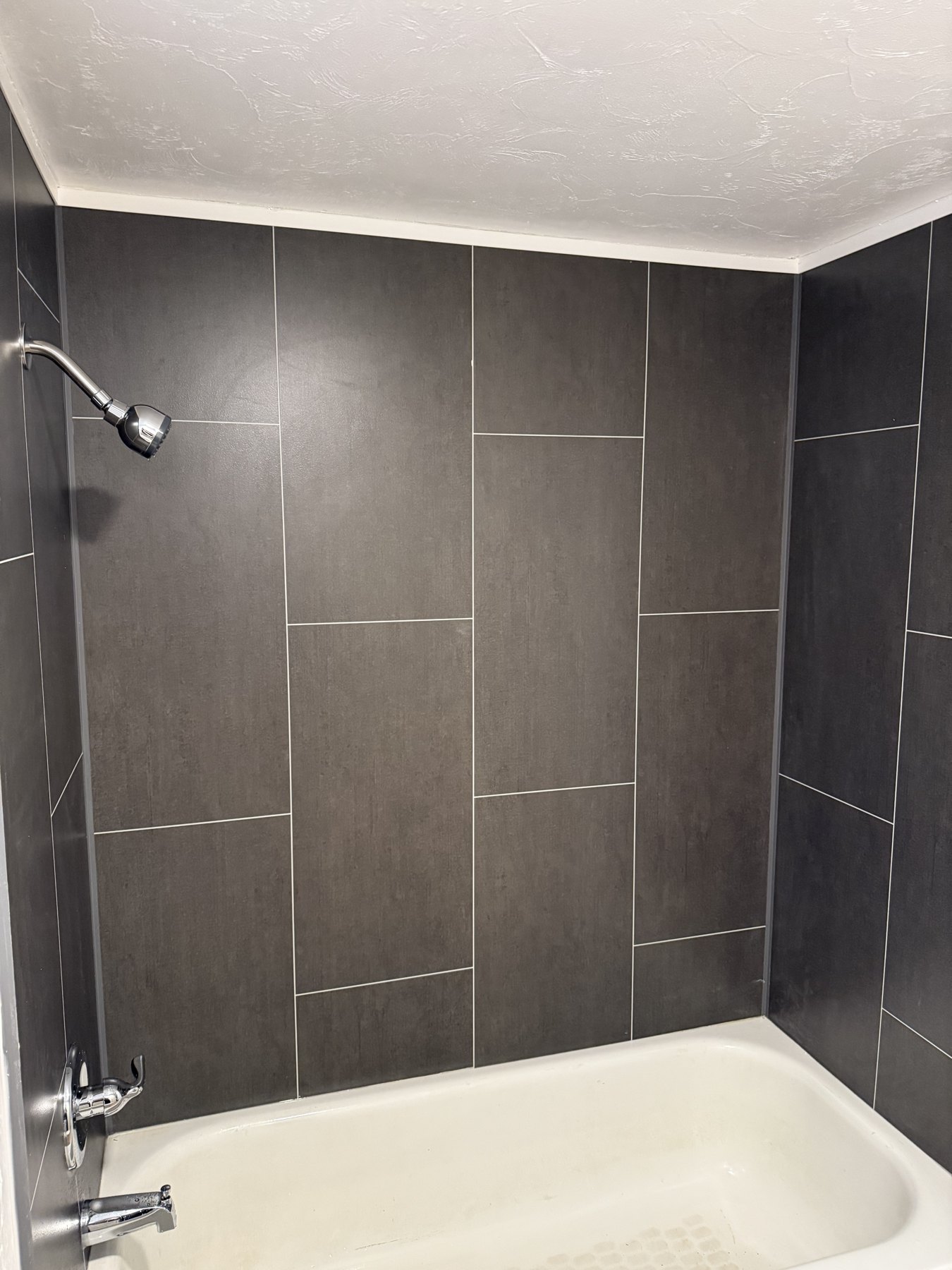 Walk-in shower with dark gray wall panels