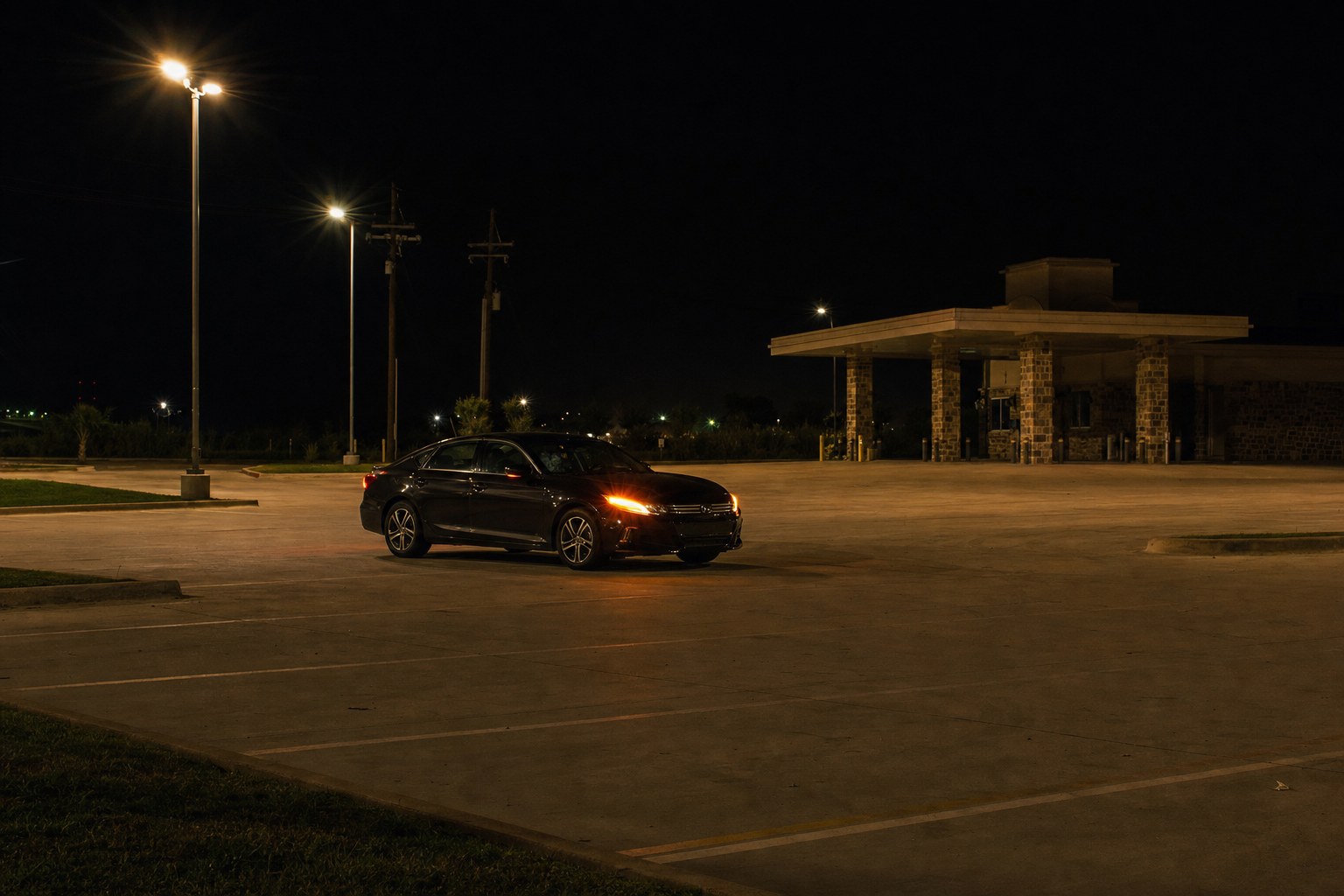 Vehicle safely parked under bright lights at night with hazard lights on