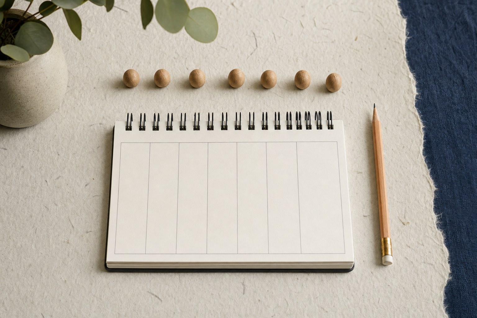 Blank weekly planner with pencil and small wooden beads