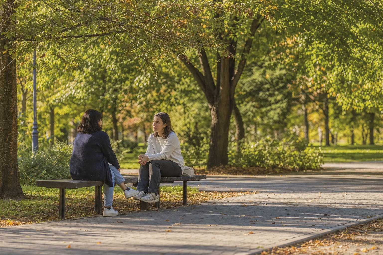 Two people having a thoughtful conversation on a park bench