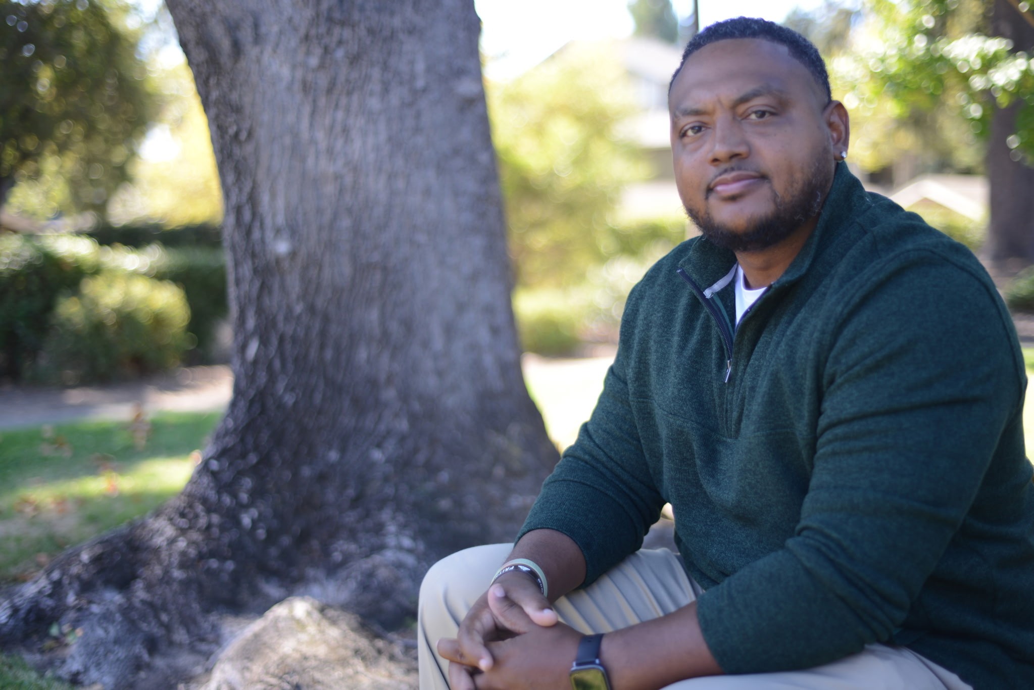 Coach Jazz Burney sitting beside a tree