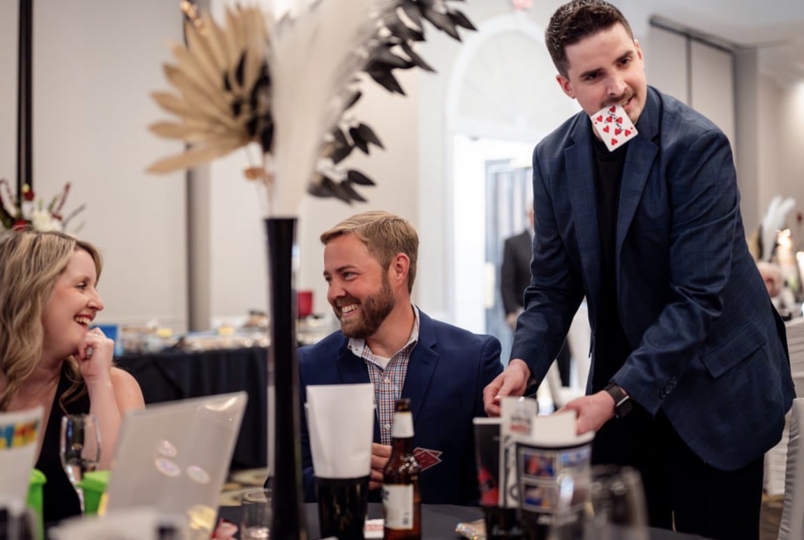 Neal Chamberlain performing a card trick for dinner guests